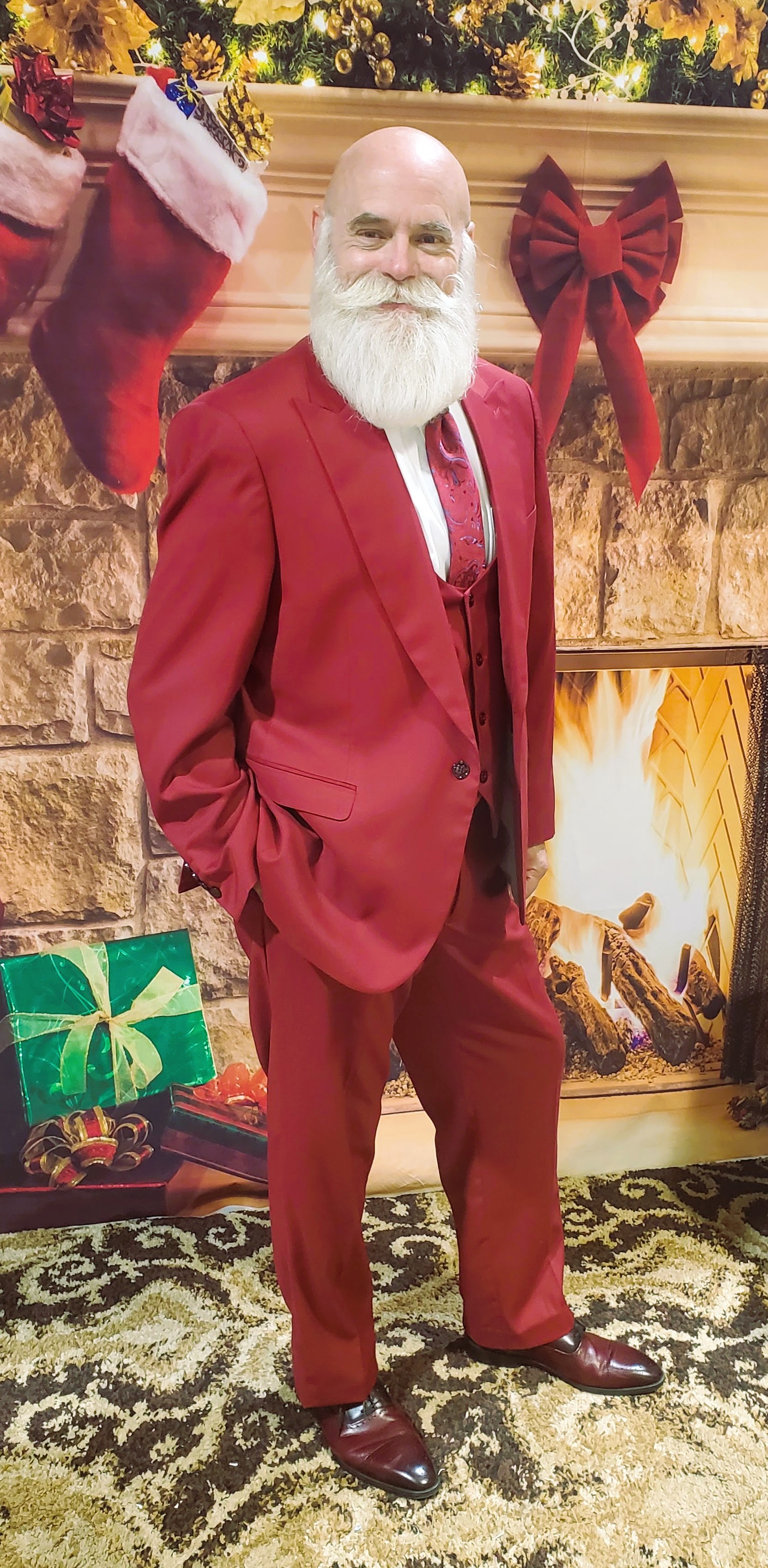 Santa standing in a tailored red suit at Christmas